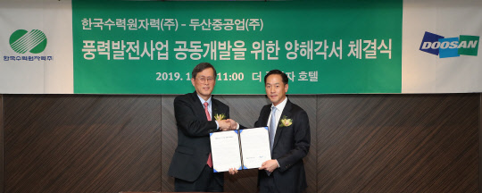 정재훈 한수원 사장(왼쪽)과 박인원 두산중공업 플랜트 EPC BG장이 양해각서를 함께 들어보이고 있다.  한국수력원자력 제공